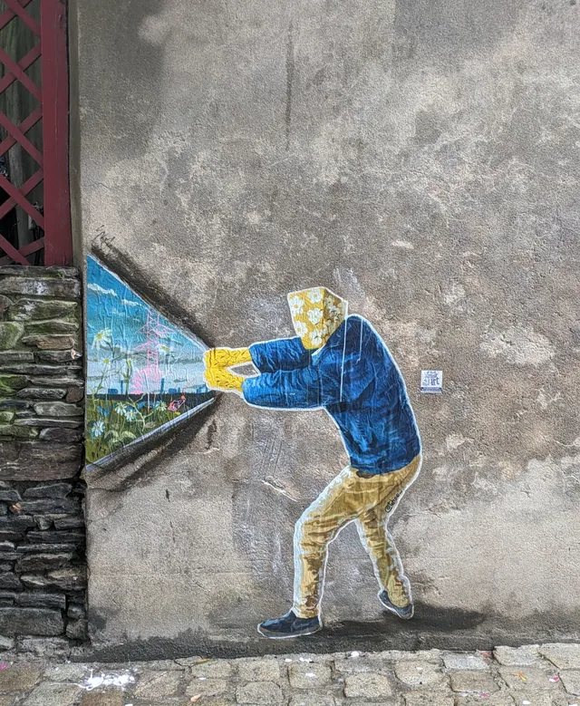 Collage sur un mur de béton, personnage penché dont le buste s'ouvre sur un paysage.