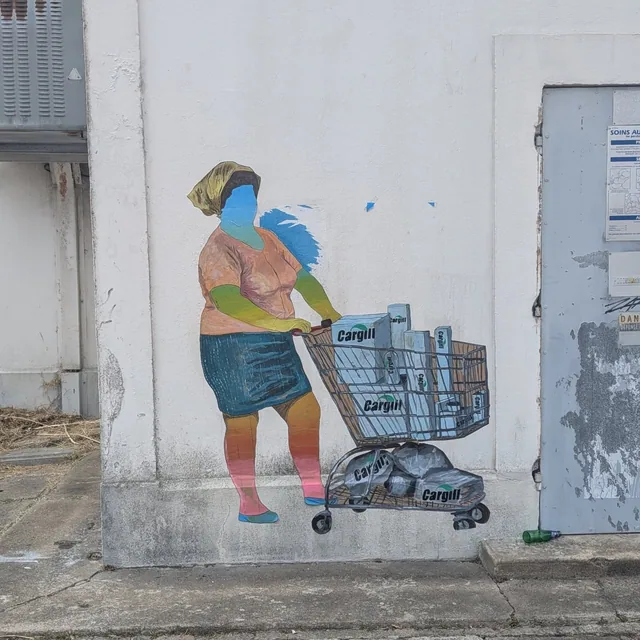 Collage sur un mur blanc, personnage poussant un caddie de supermarché.